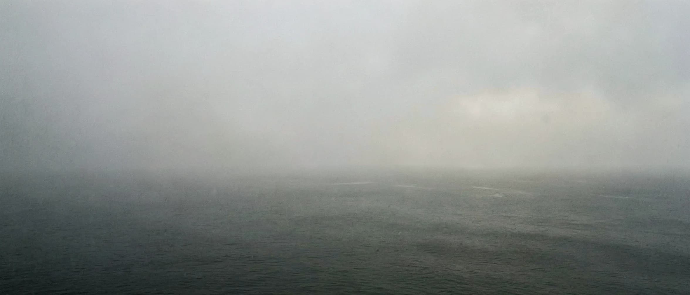 Dichte zeemist over een spiegelgladde donkere watermassa
