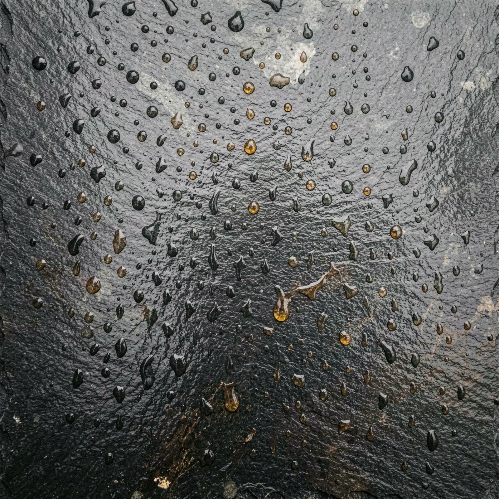 Natte leisteen met regendruppels en droogvlekken