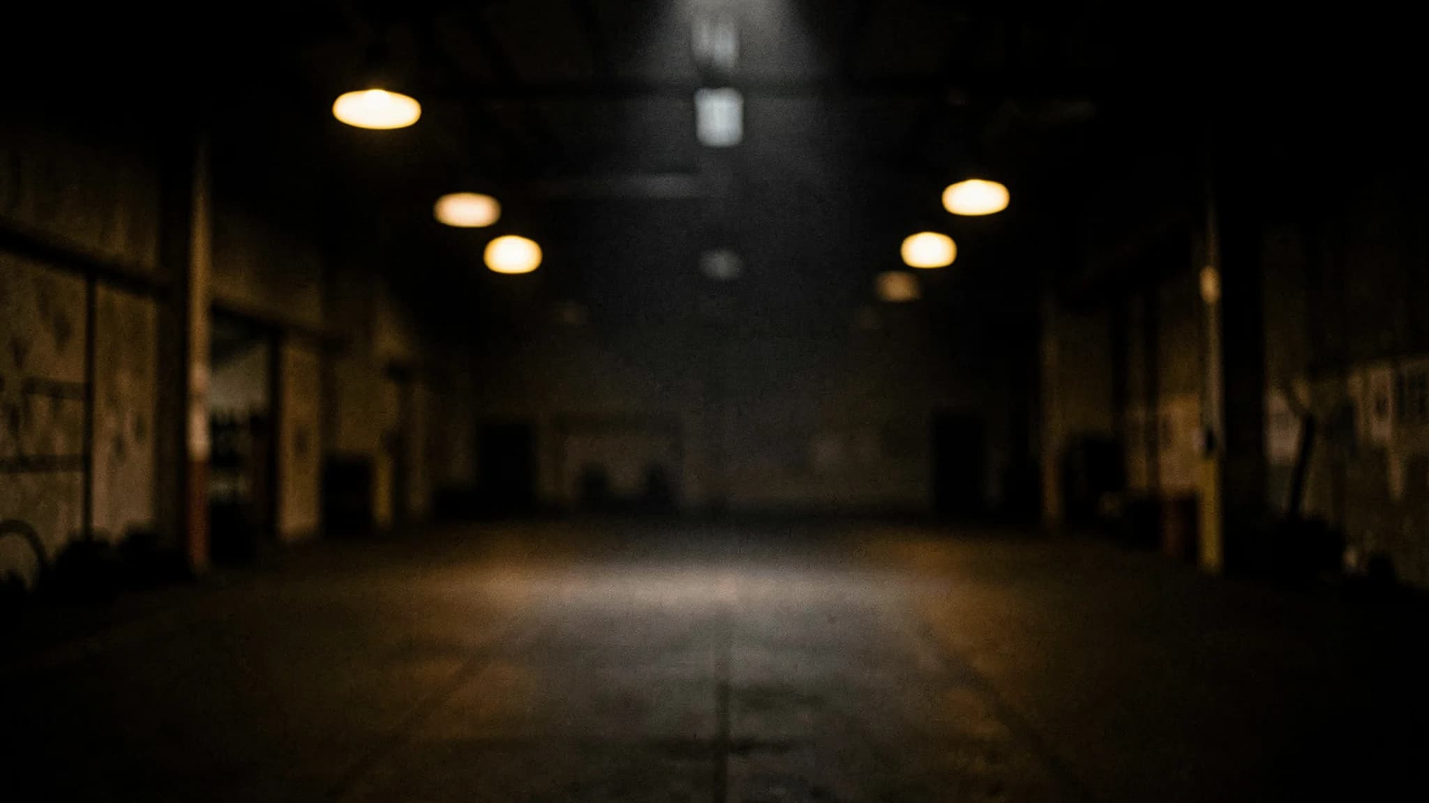 Onscherpe trainingszaal met verspreide amberkleurige lichtpunten in het donker