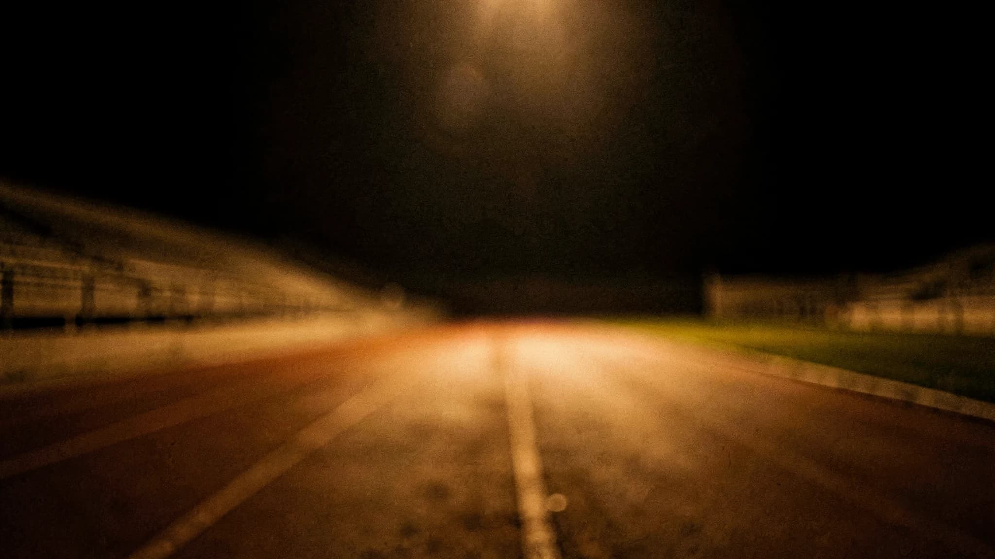 Vervaagde atletiekbaan in de nacht met zachte kleurvlakken