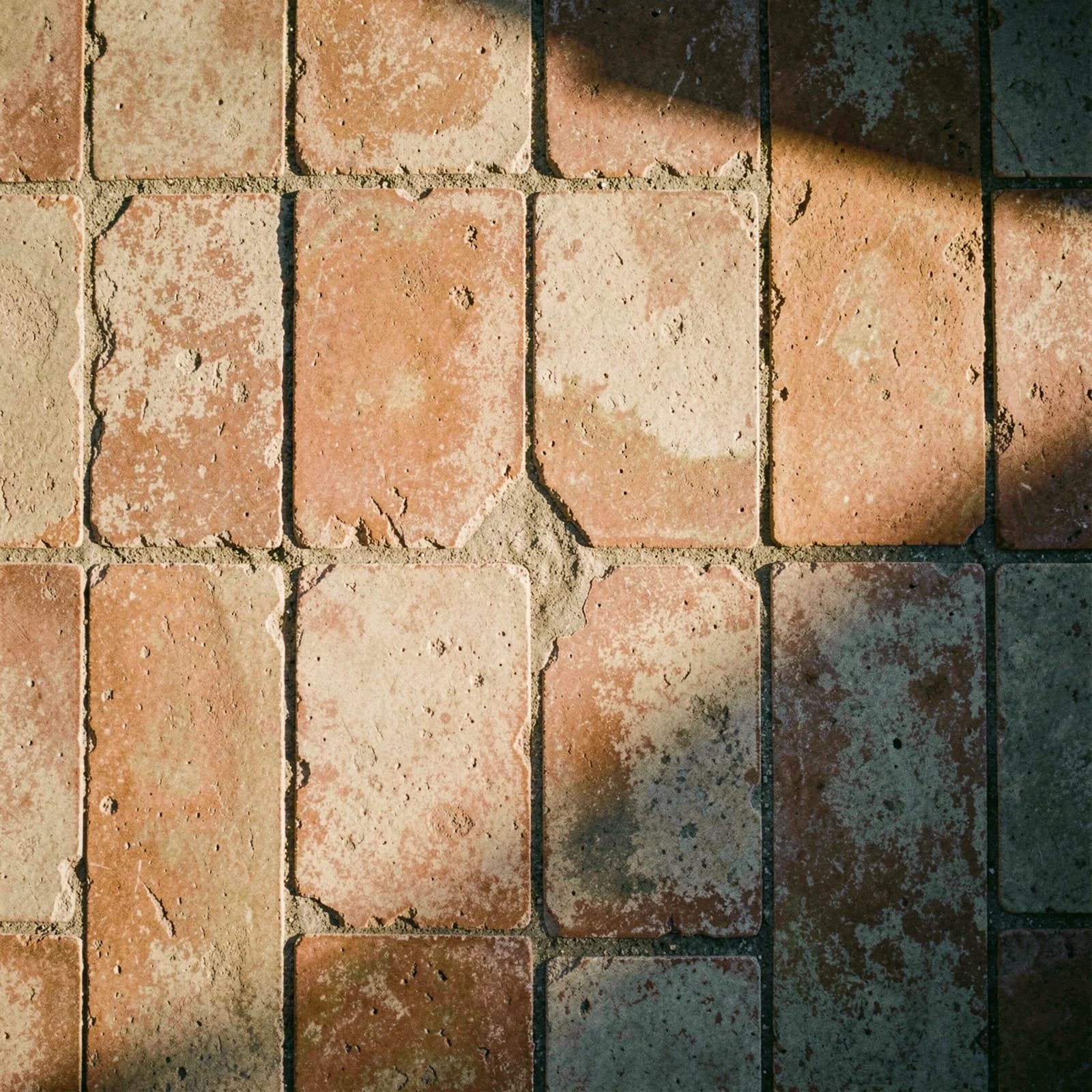 Gladgesleten terracotta vloertegels met donkere voegen