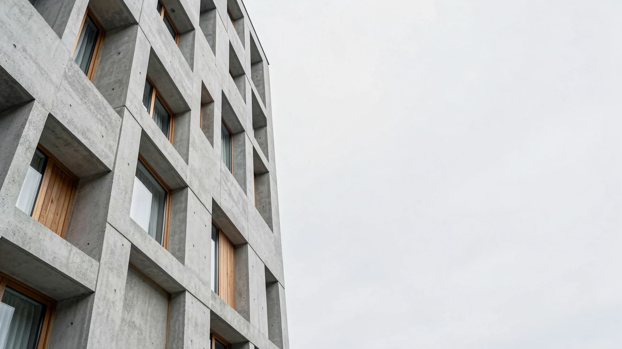 Bekist betonnen gevel met diepe raamopeningen
