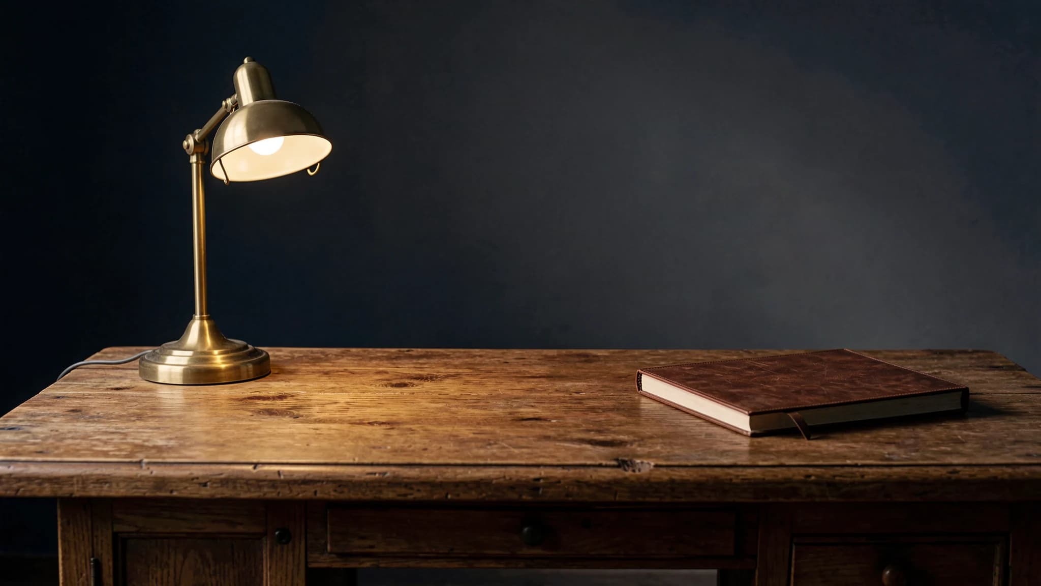 Eikenhouten bureau met messing lamp en lederen map