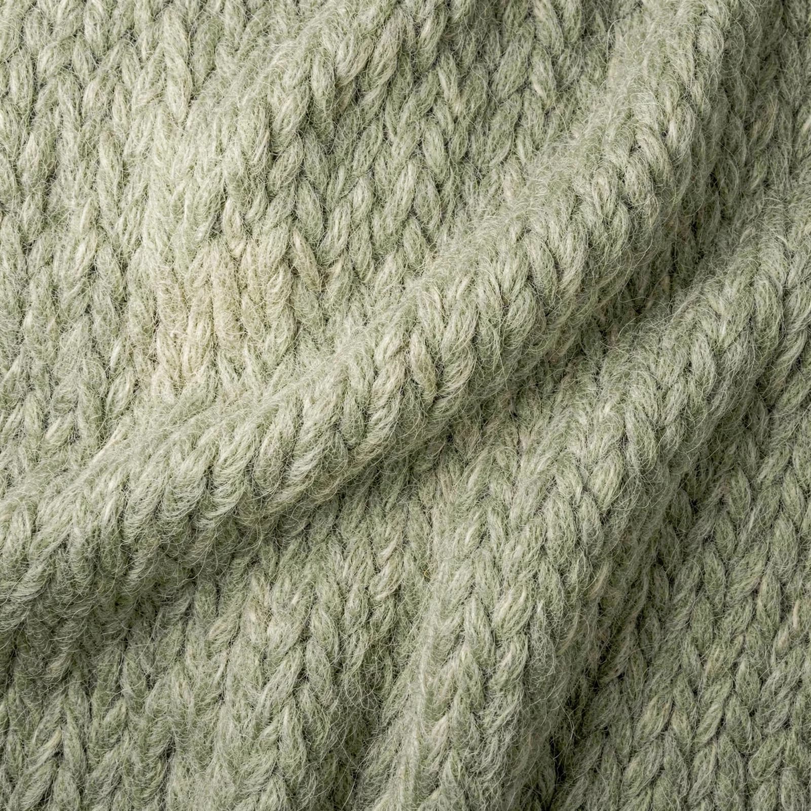 Zachte lussenstructuur van een saliegroene wollen deken