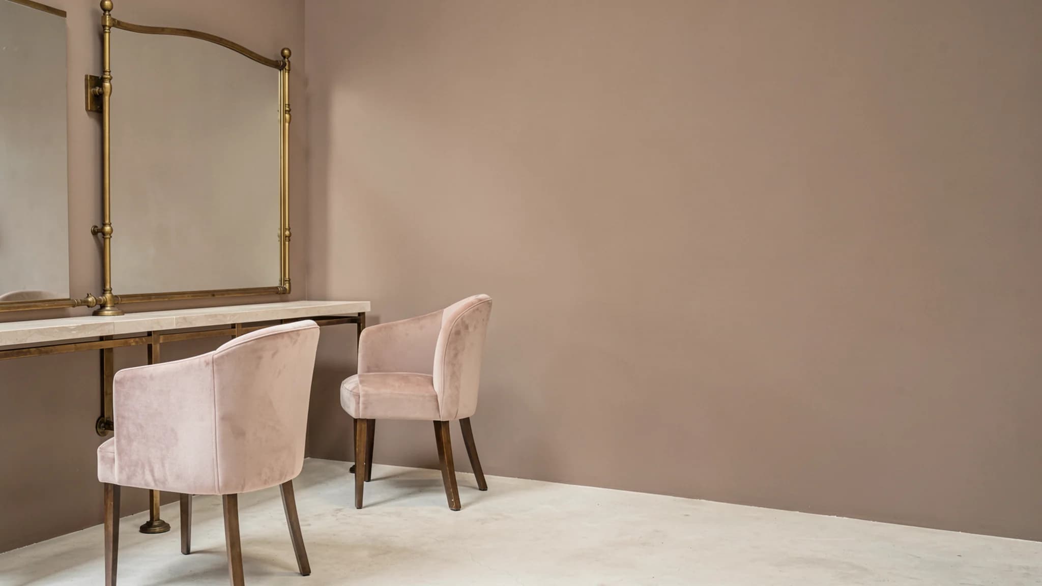 Twee gestoffeerde salonstoelen voor een lange spiegel